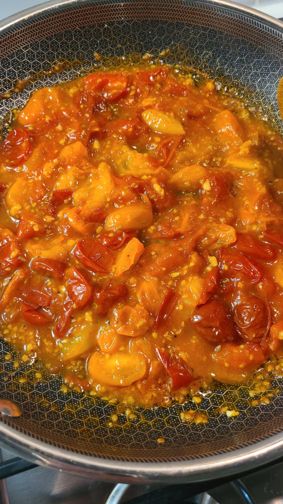 Cherry tomatoes breaking down into sauce