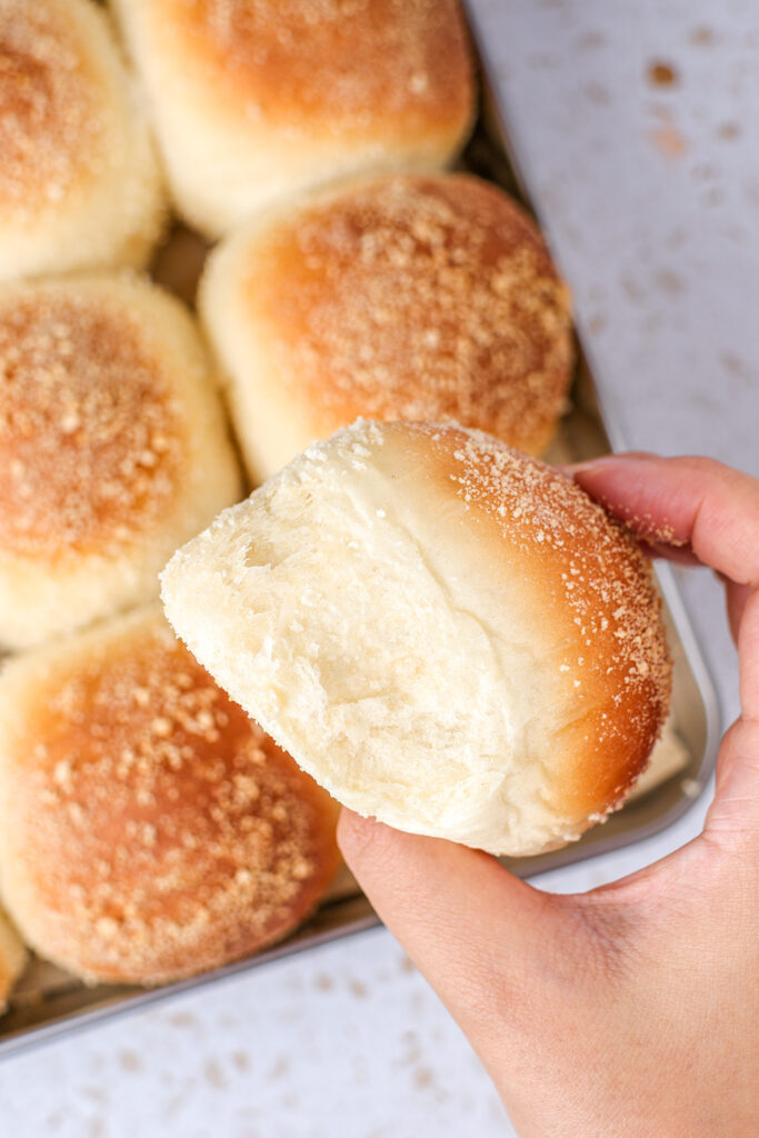 A roll of Pandesal, held in a hand